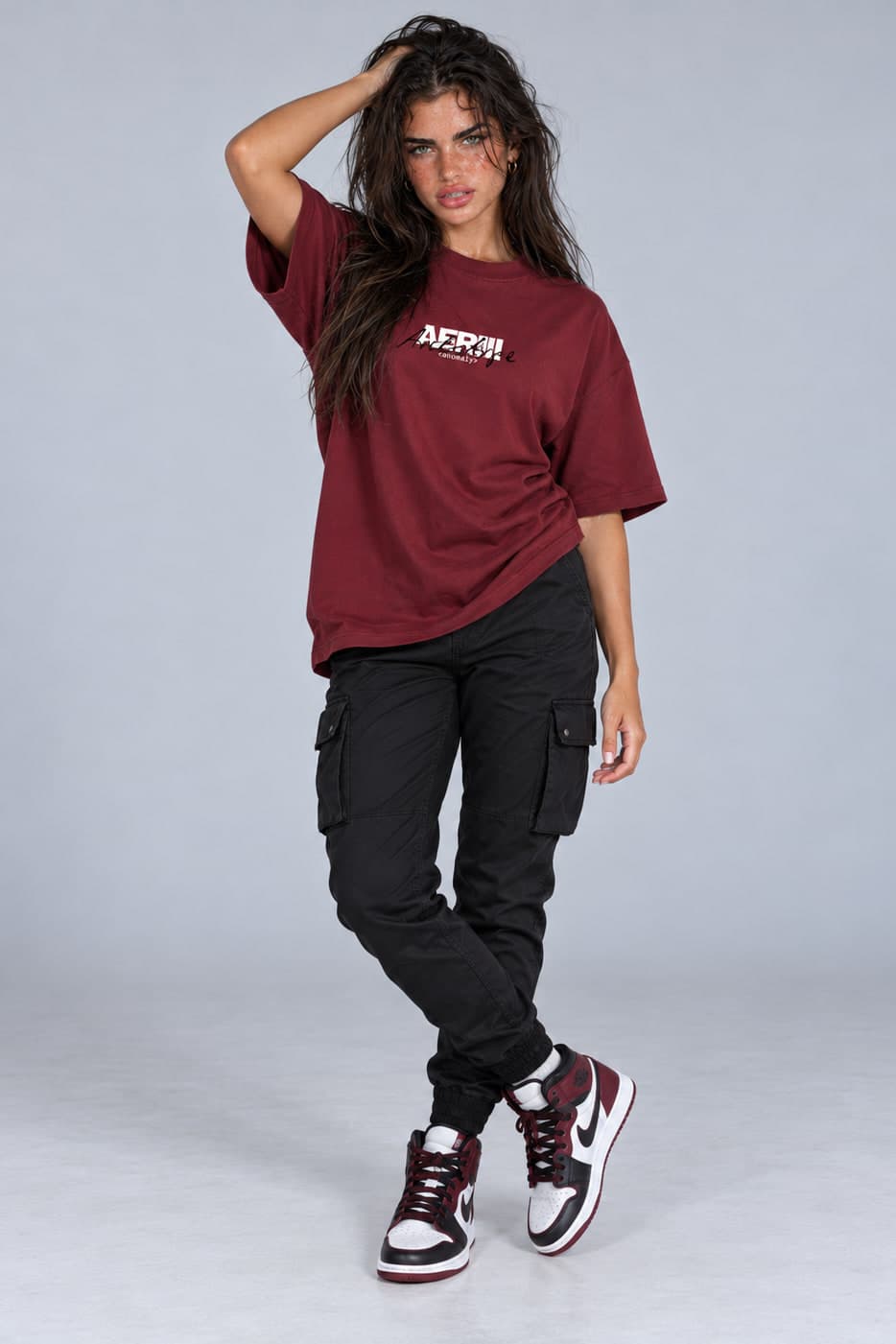 ARCHETYPE tee in burgundy, posed, full length, on a female model